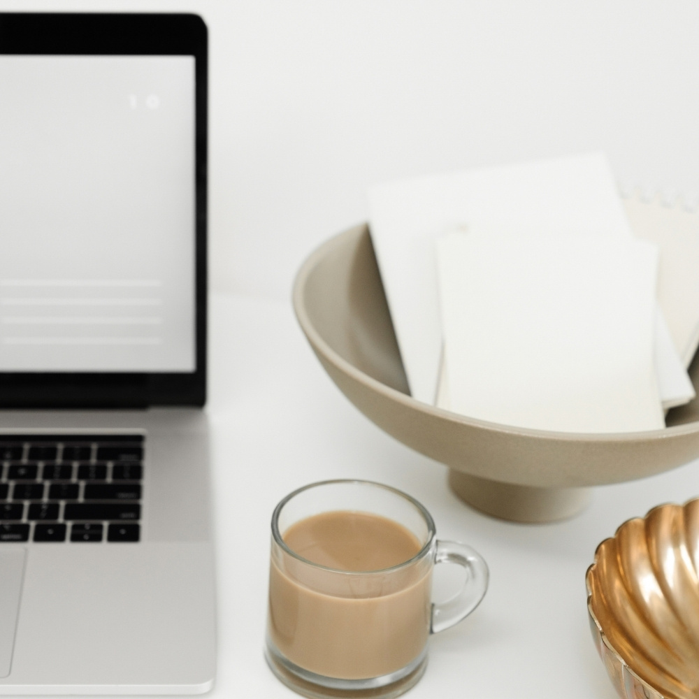 laptop and coffee on white desk